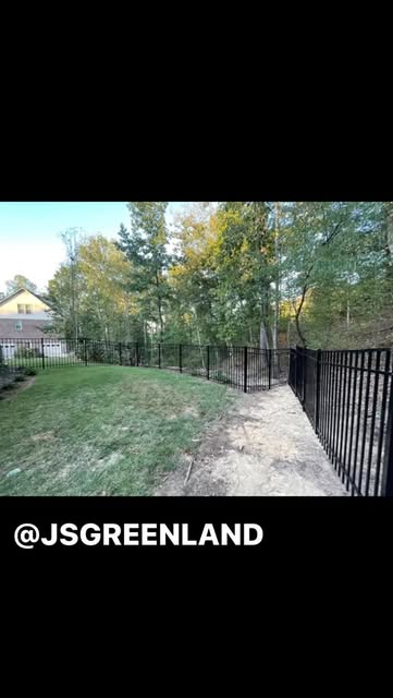 Black metal fence installed along a landscaped yard